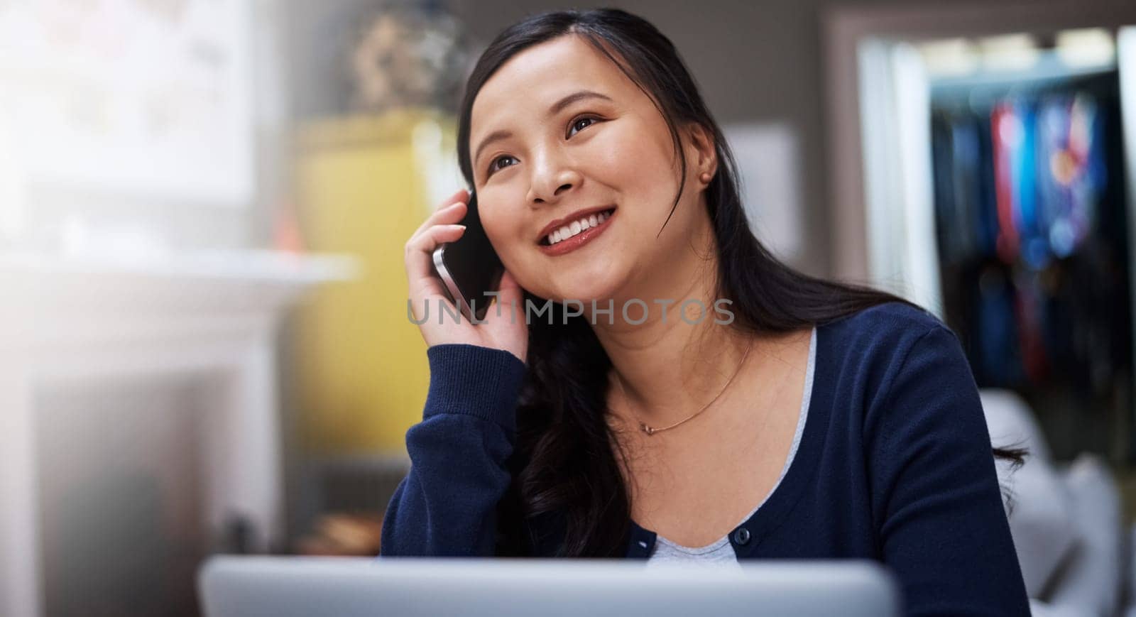Shes always reachable at the home office. an attractive young female entrepreneur making a call while working from home. by YuriArcurs