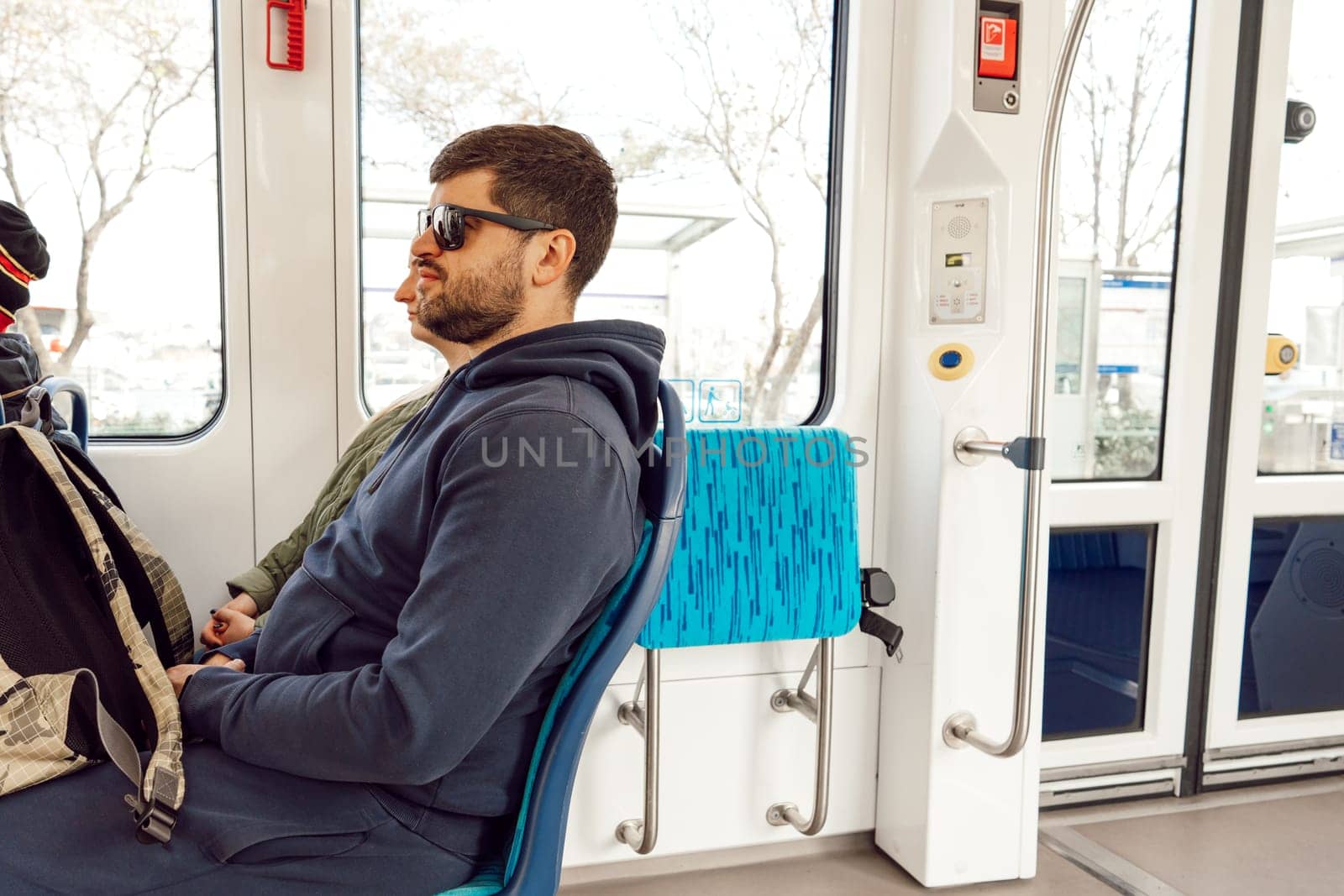 Young man on a public transport in the city travelling by Fabrikasimf