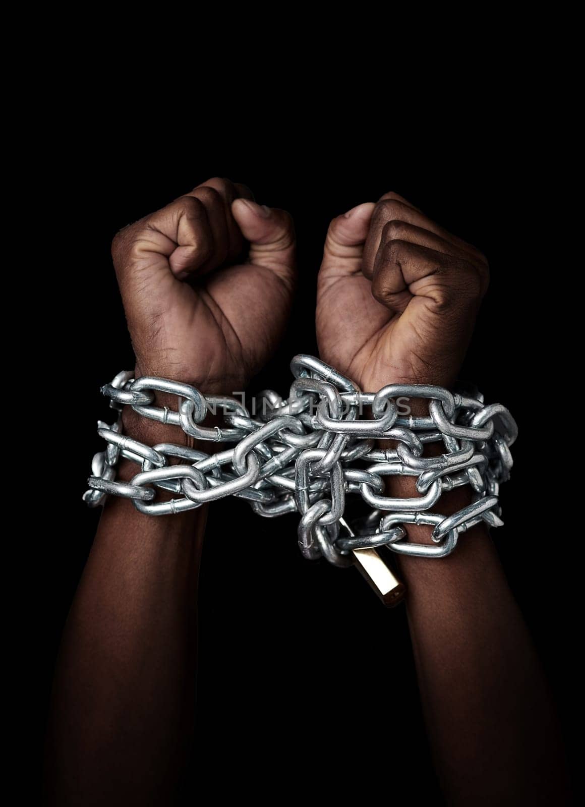 Chain, hands and prisoner of slavery isolated in studio on a black background. Chained, slave and hand of person in bondage, hostage or criminal in jail after arrest for crime, law and punishment