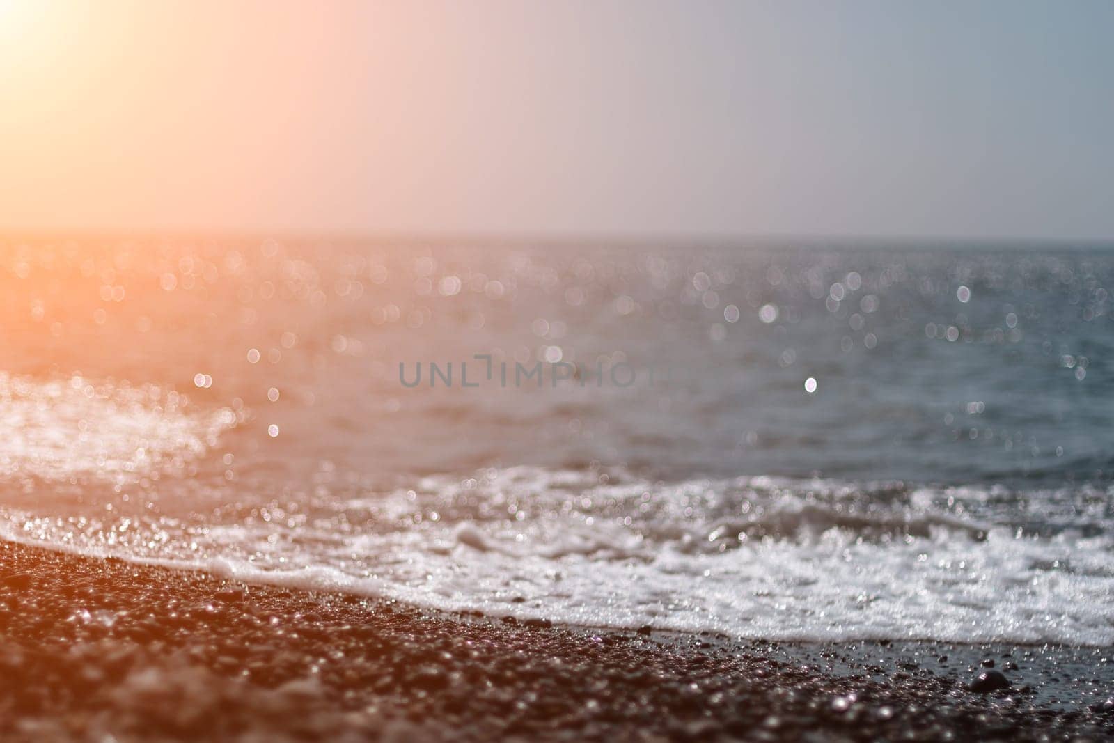 Abstract nature summer ocean sunset sea background. Small waves on water surface in motion blur with bokeh lights from sunrise. Holiday, vacation and recreational background concept by panophotograph