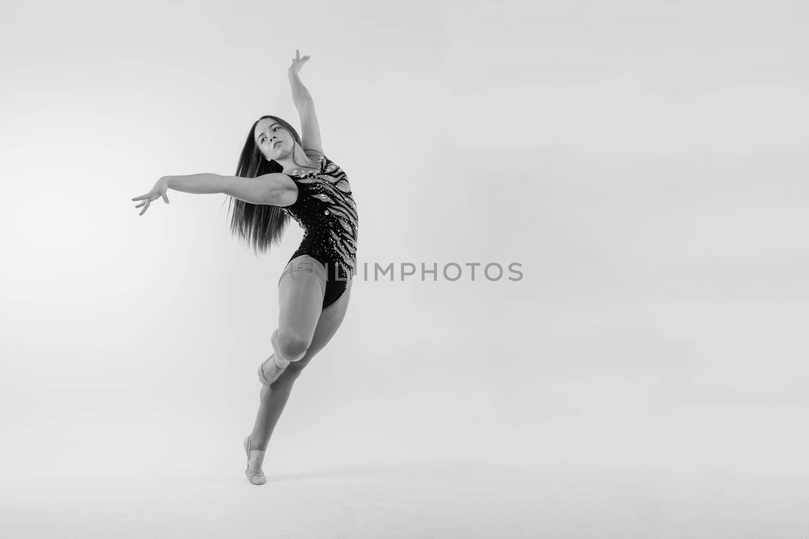 Sportive exercises, standing and stretching the hands. Beautiful muscular woman in indoors studio.