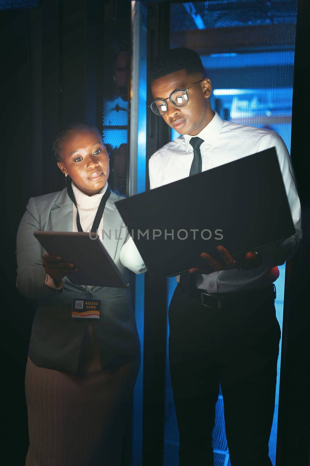 Take a look at this. two young IT specialists standing in the server room and having a discussion while using a technology