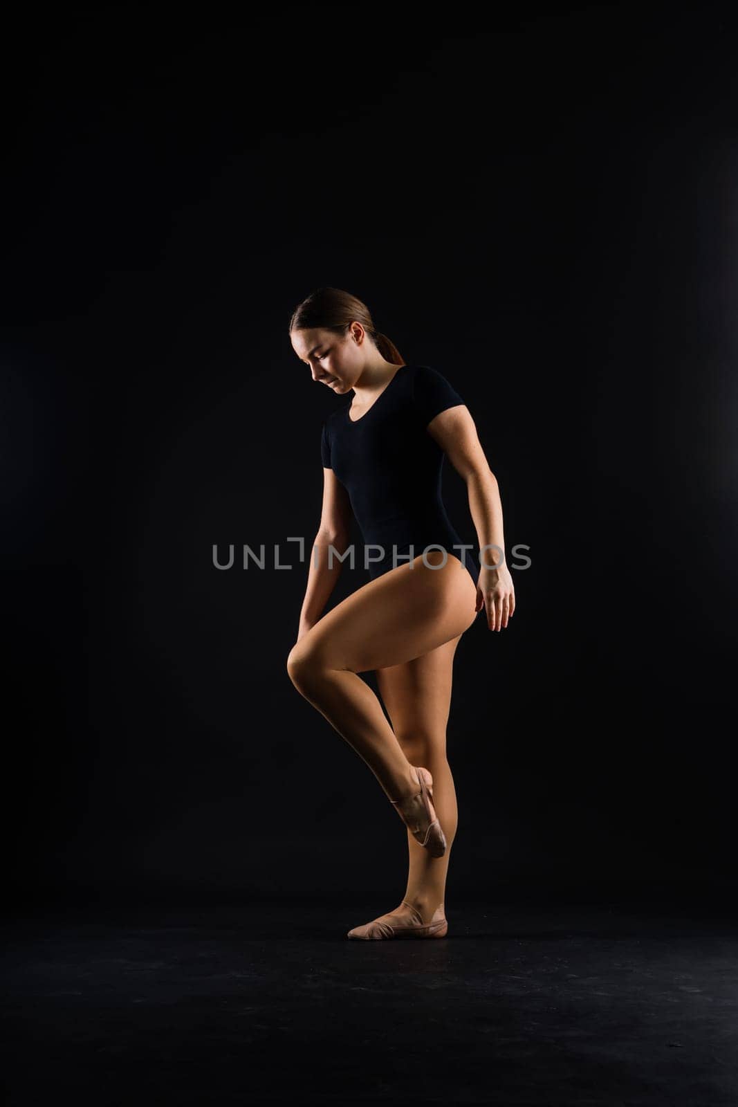 Sportive exercises, standing and stretching the hands. Beautiful muscular woman is indoors studio. by Zelenin