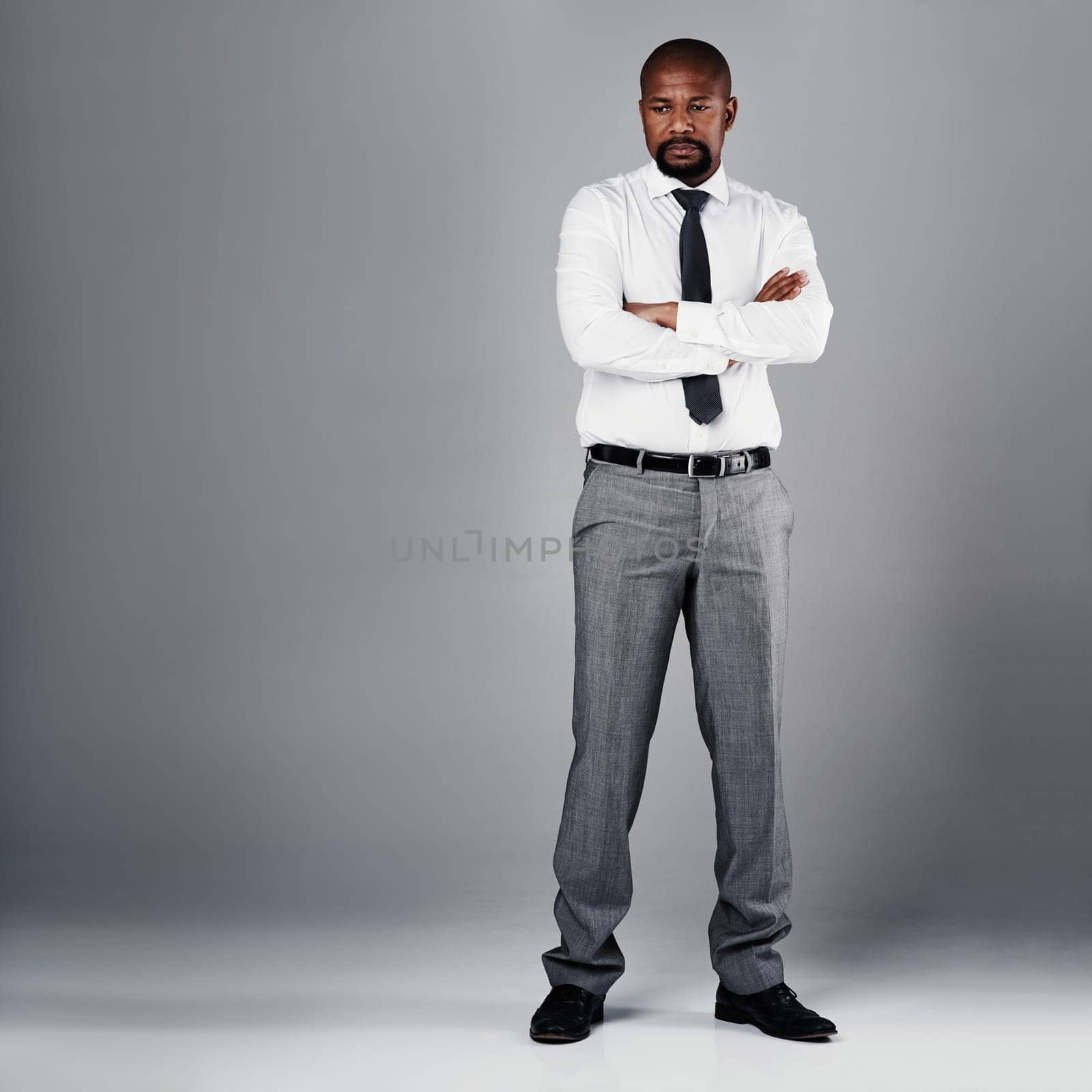 Ready for business. Studio shot of a corporate businessman posing against a grey background