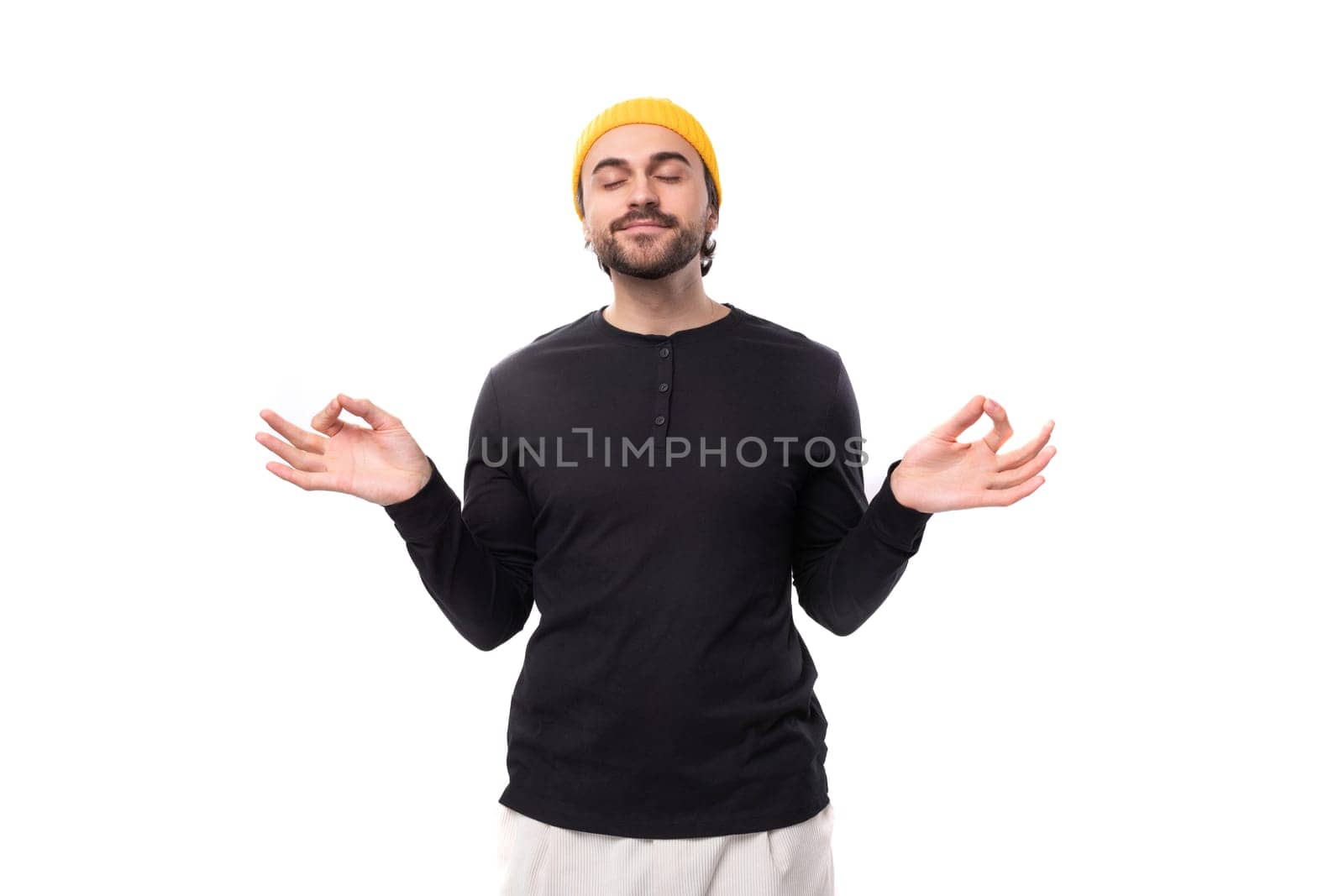 young brunet caucasian male model with beard dressed casual meditating.