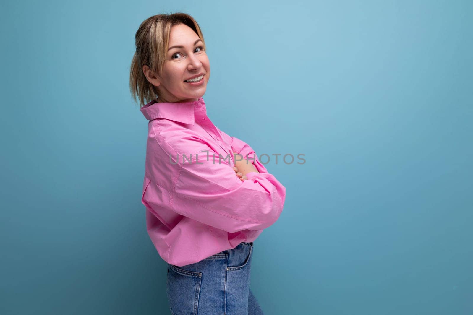 young energetic European blond leader woman with ponytail dressed in a pink blouse on the background with copy space by TRMK