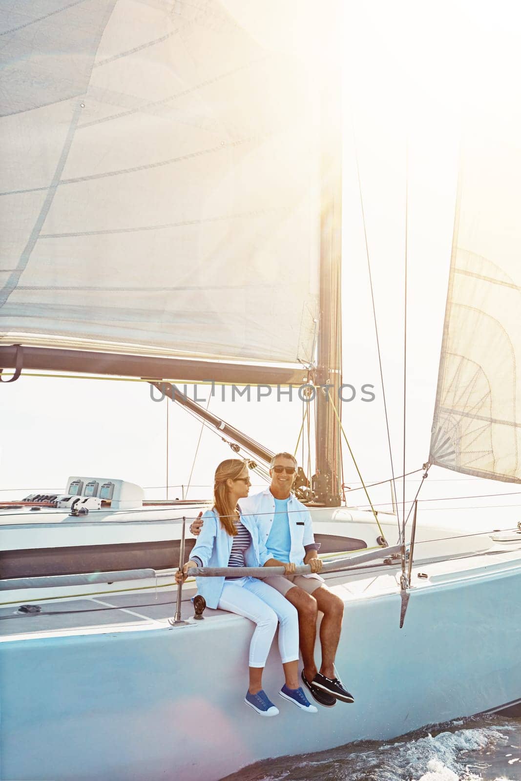 Couple, boat and adventure at sea for holiday during summer to relax on luxury or rich cruise. Ocean, vacation and people on yacht for outdoor travel and freedom to enjoy the sunshine together