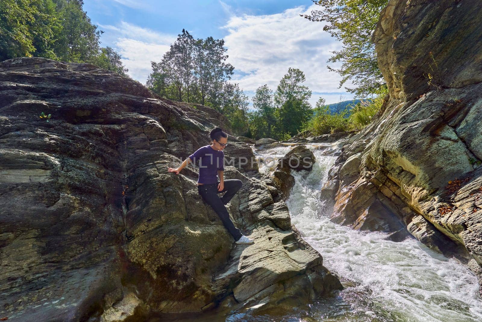 Young woman tourist near a mountain stormy river.Rock formations and stones by jovani68