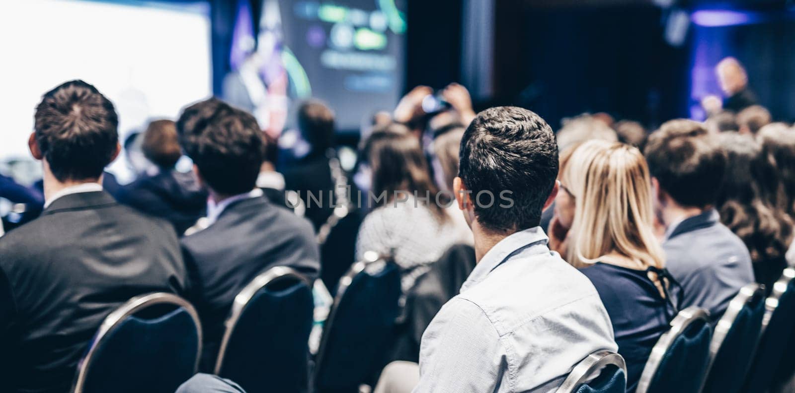 Speaker giving a talk in conference hall at business event. Rear view of unrecognizable people in audience at the conference hall. Business and entrepreneurship concept. by kasto