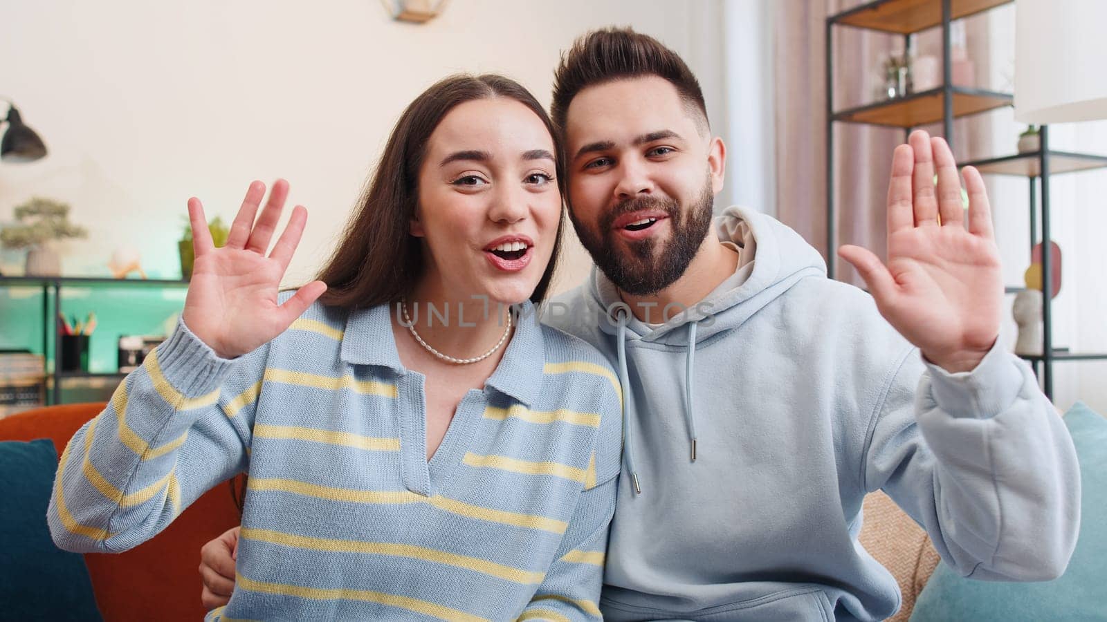 POV of family marriage couple man woman making video laptop webcam conference call with friends or family, enjoying pleasant conversation at home. Husband wife laughing, waving hello looking at camera