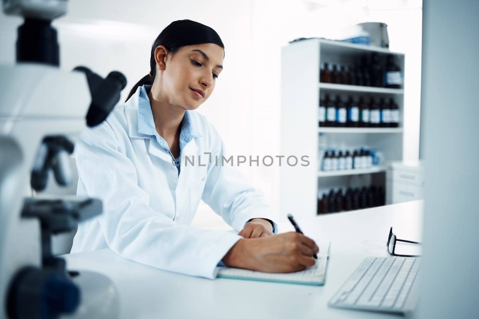 Woman, scientist and writing notes in science research for discovery, breakthrough or information at lab. Female person or medical expert with notebook for scientific data or results in laboratory.