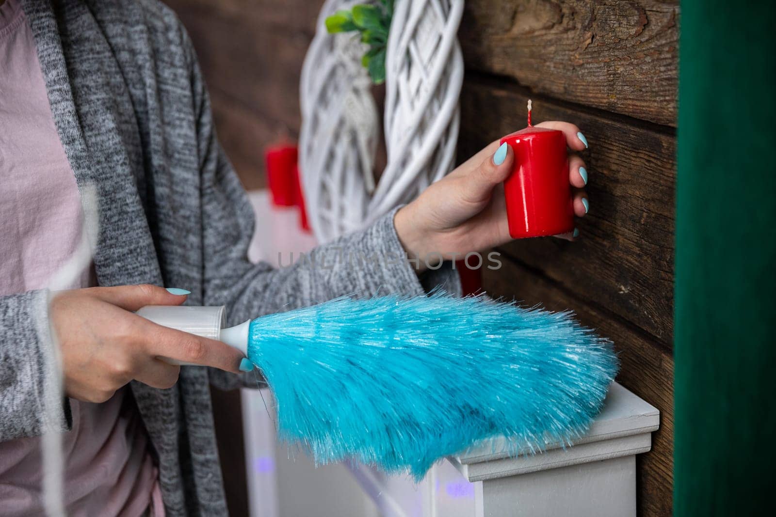 Under each object must be thoroughly cleaned to make the whole room sparkle for Christmas. The girl holds a red candle in her hand.