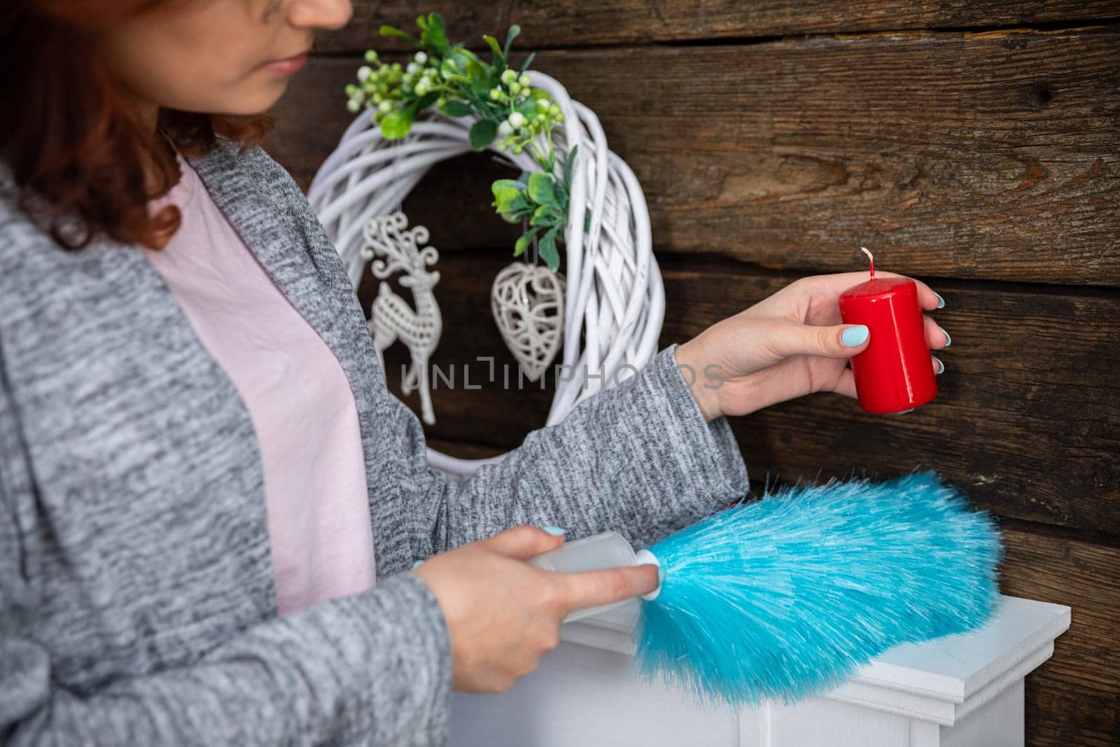 Under each object must be thoroughly cleaned to make the whole room sparkle for Christmas. The girl holds a red candle in her hand.