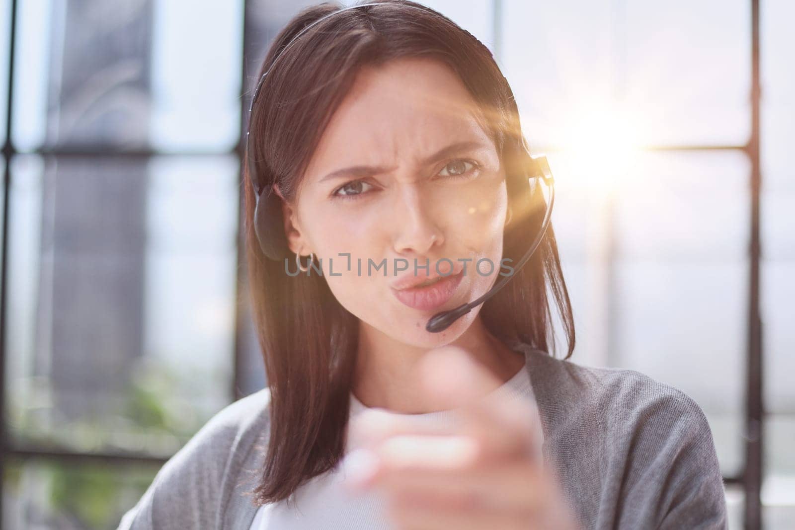 Smiling support phone woman operator in office. pointing at you