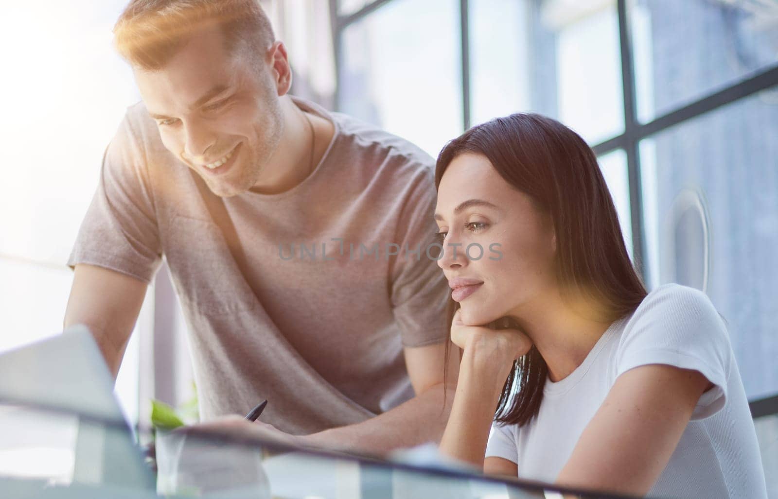 male ceo executive manager mentor giving consultation on financial operations to female colleague intern using laptop sitting in modern office