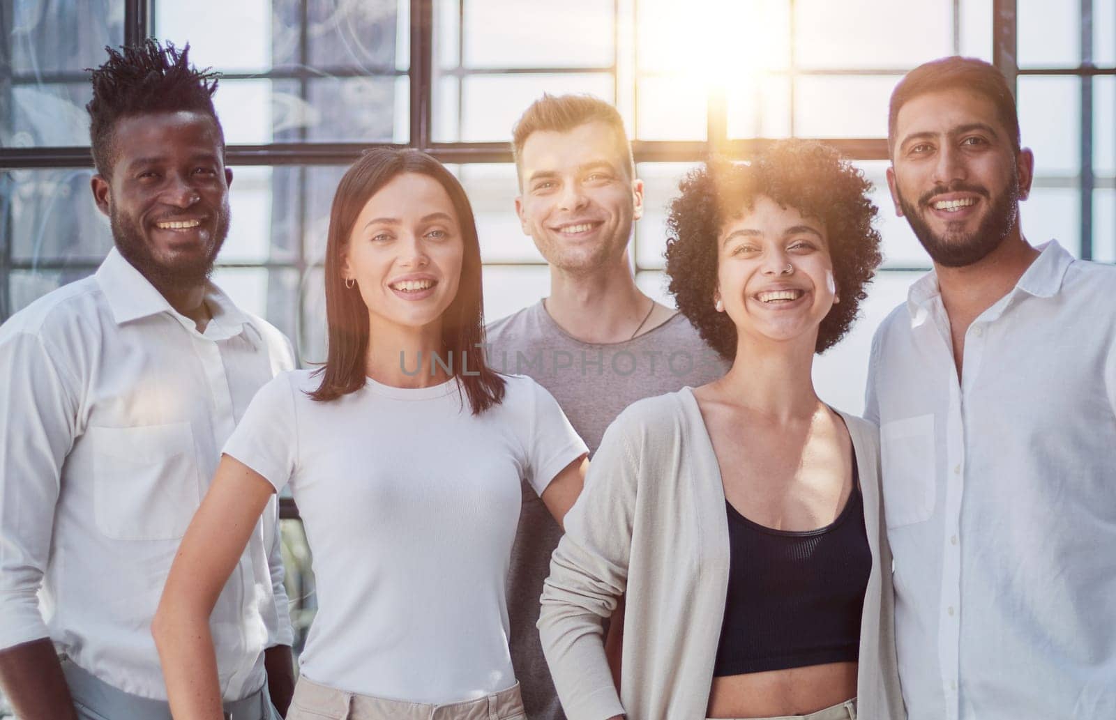 Portrait of successful creative business team looking at camera and smiling. Diverse business people standing together at startup.
