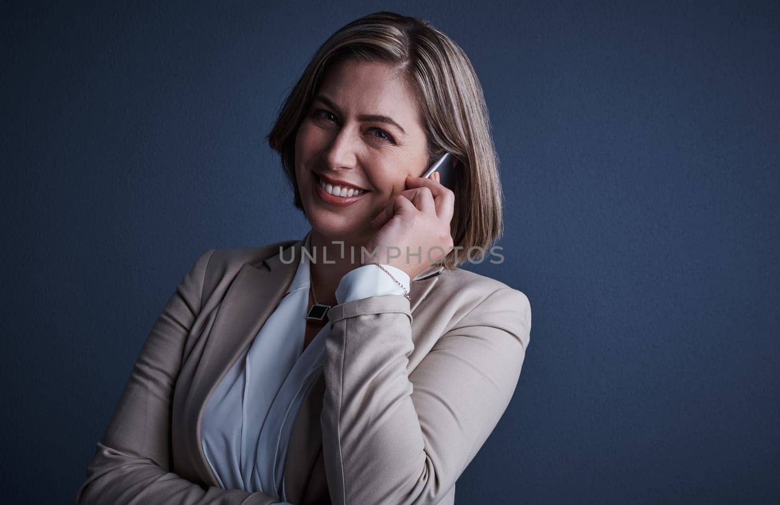 You can call me, anytime. Studio portrait of an attractive young corporate businesswoman making a call against a dark background