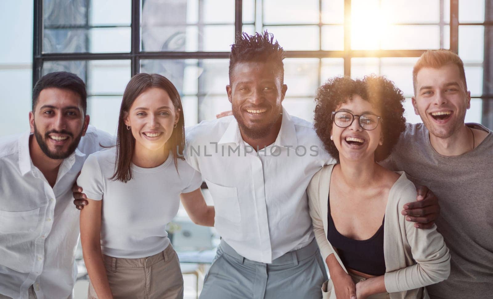 Portrait of successful creative business team looking at camera and smiling. Diverse business people standing together at startup.