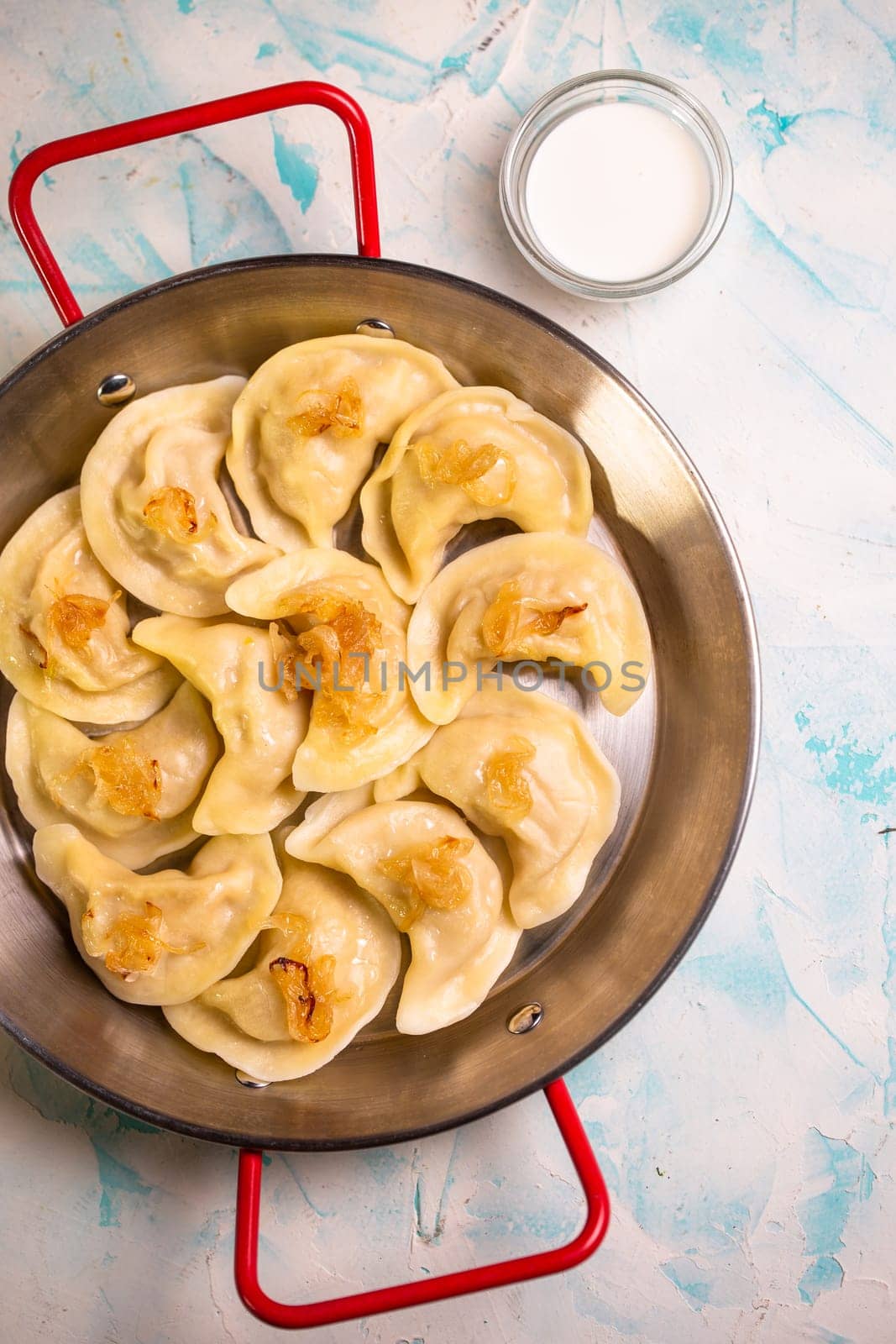 dumplings with potatoes in a frying pan top view.