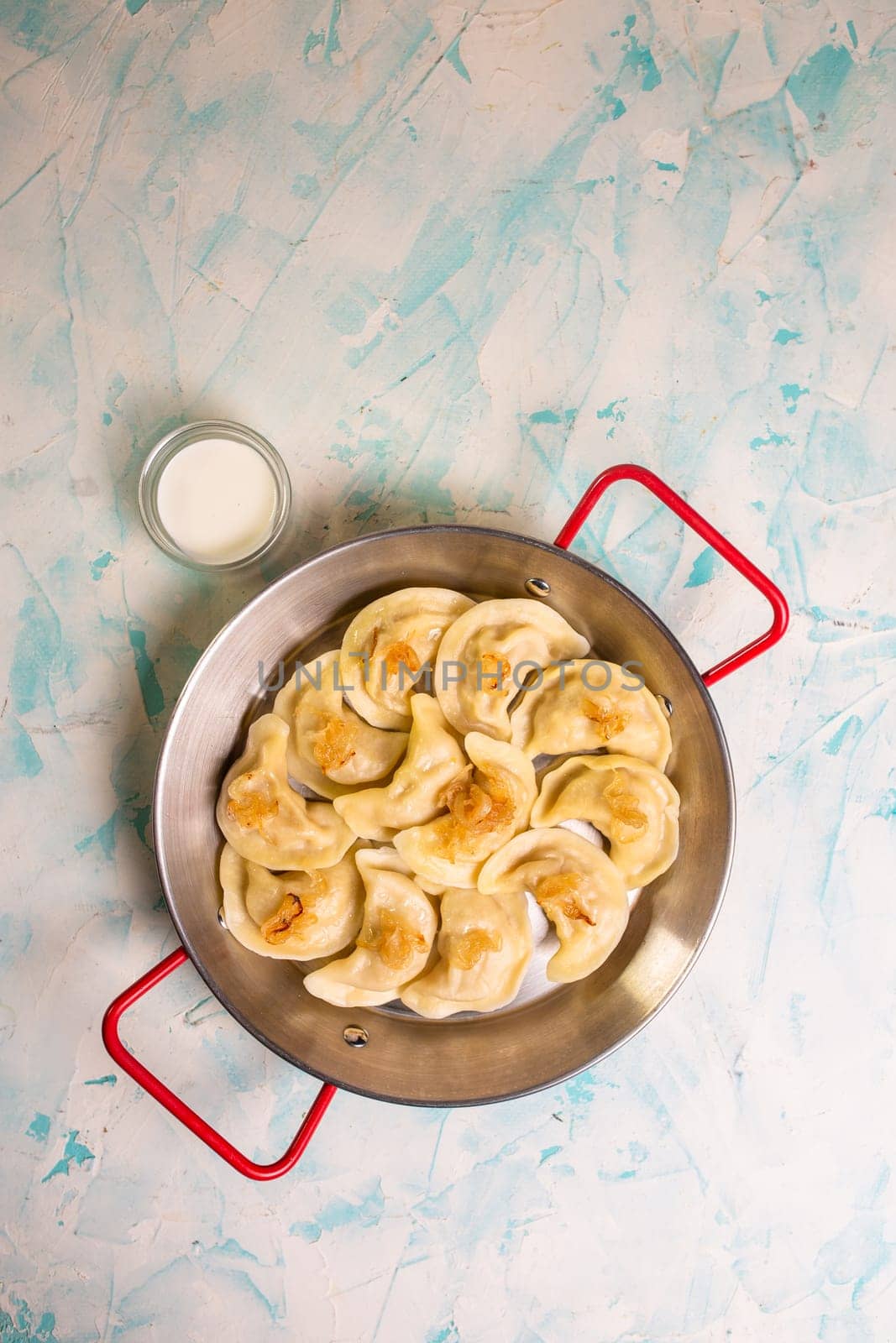 dumplings with potatoes in a frying pan top view by Pukhovskiy