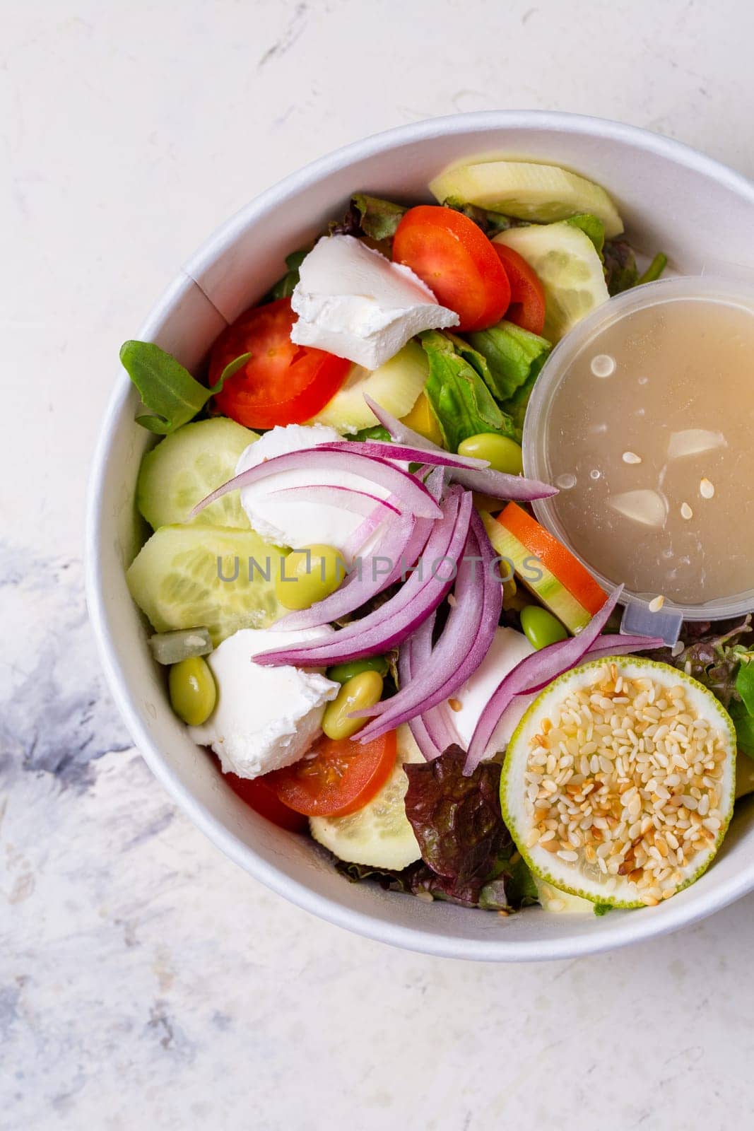 vegetable salad with cheese and sauce on a white background top view by Pukhovskiy