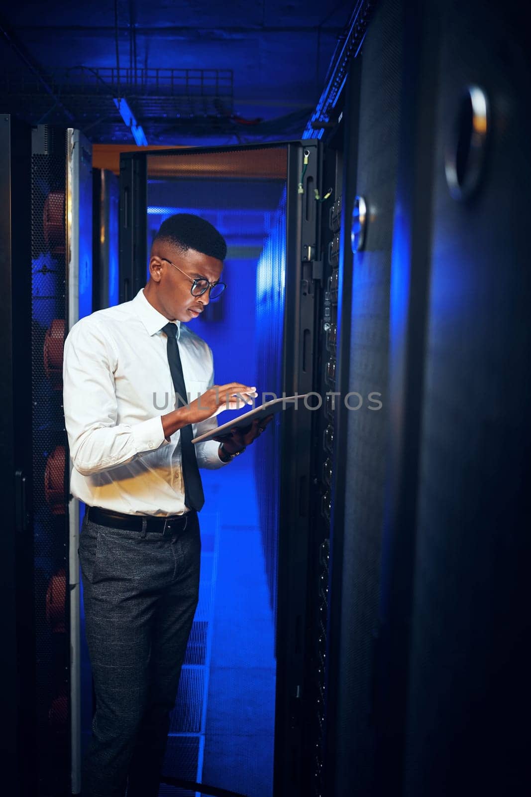 Ill connect to the main server and see whats the issue. a young man using a digital tablet while working in a server room. by YuriArcurs