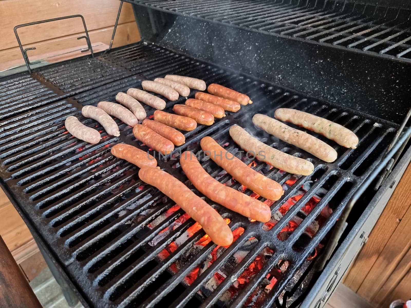 Delicious german sausages sizzling over the coals on barbecue grill