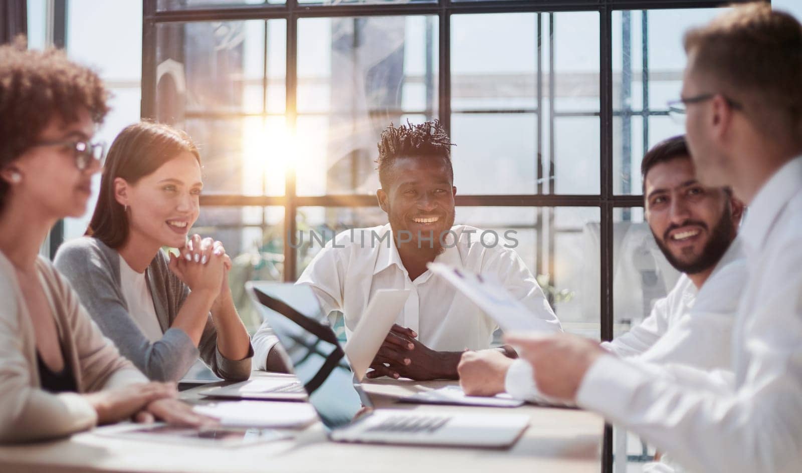 Happy young female employee discussing online project, showing computer presentation to skilled team leader in eyeglasses. Friendly diverse colleagues working in pairs on laptop, using applications.