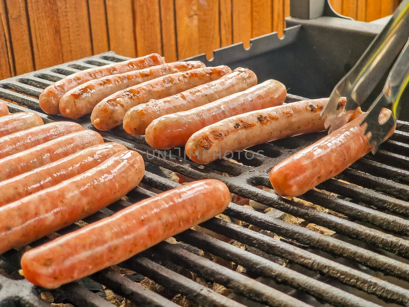 Delicious german sausages sizzling over the coals on barbecue grill