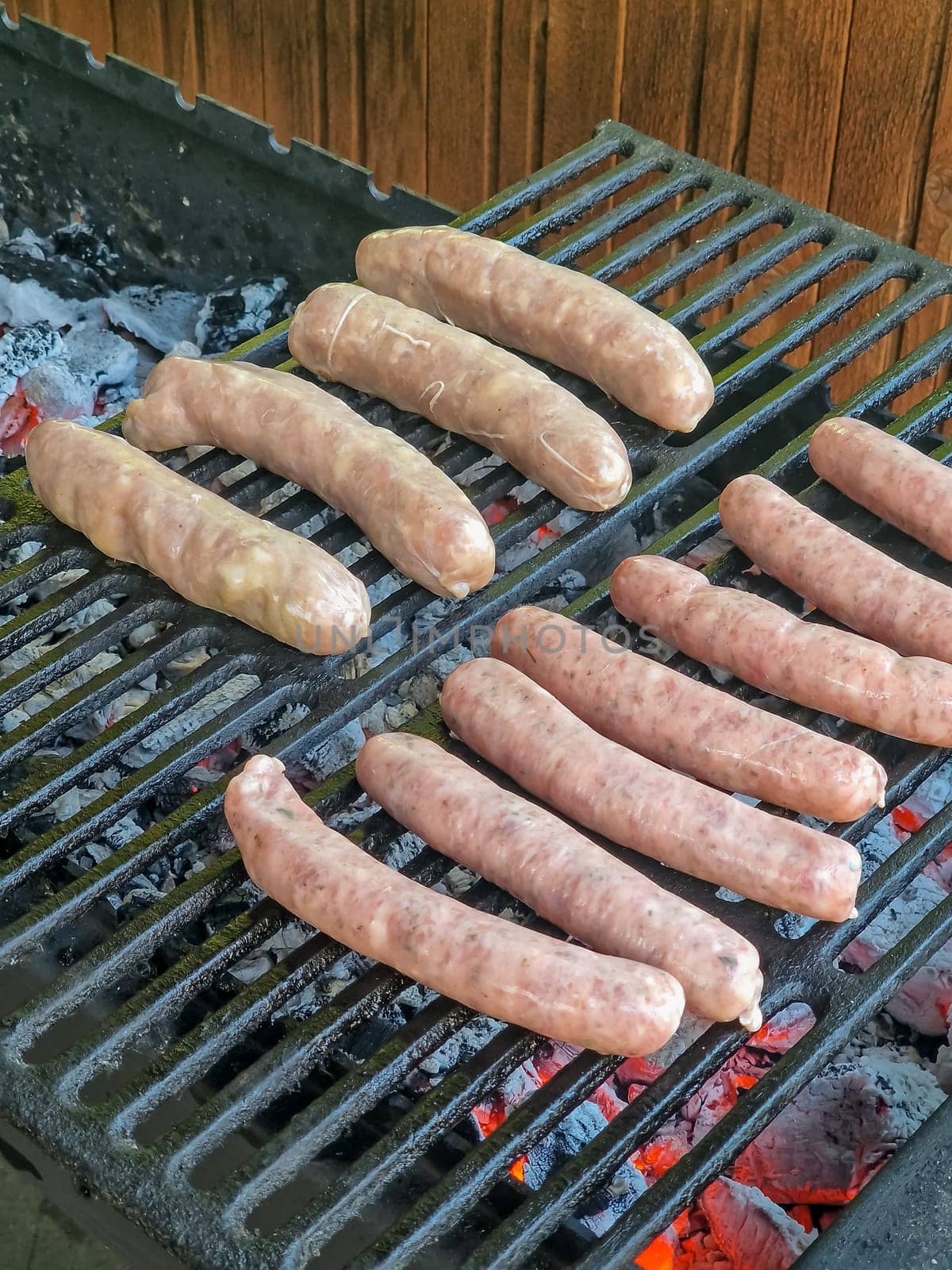 Delicious german sausages sizzling over the coals on barbecue grill