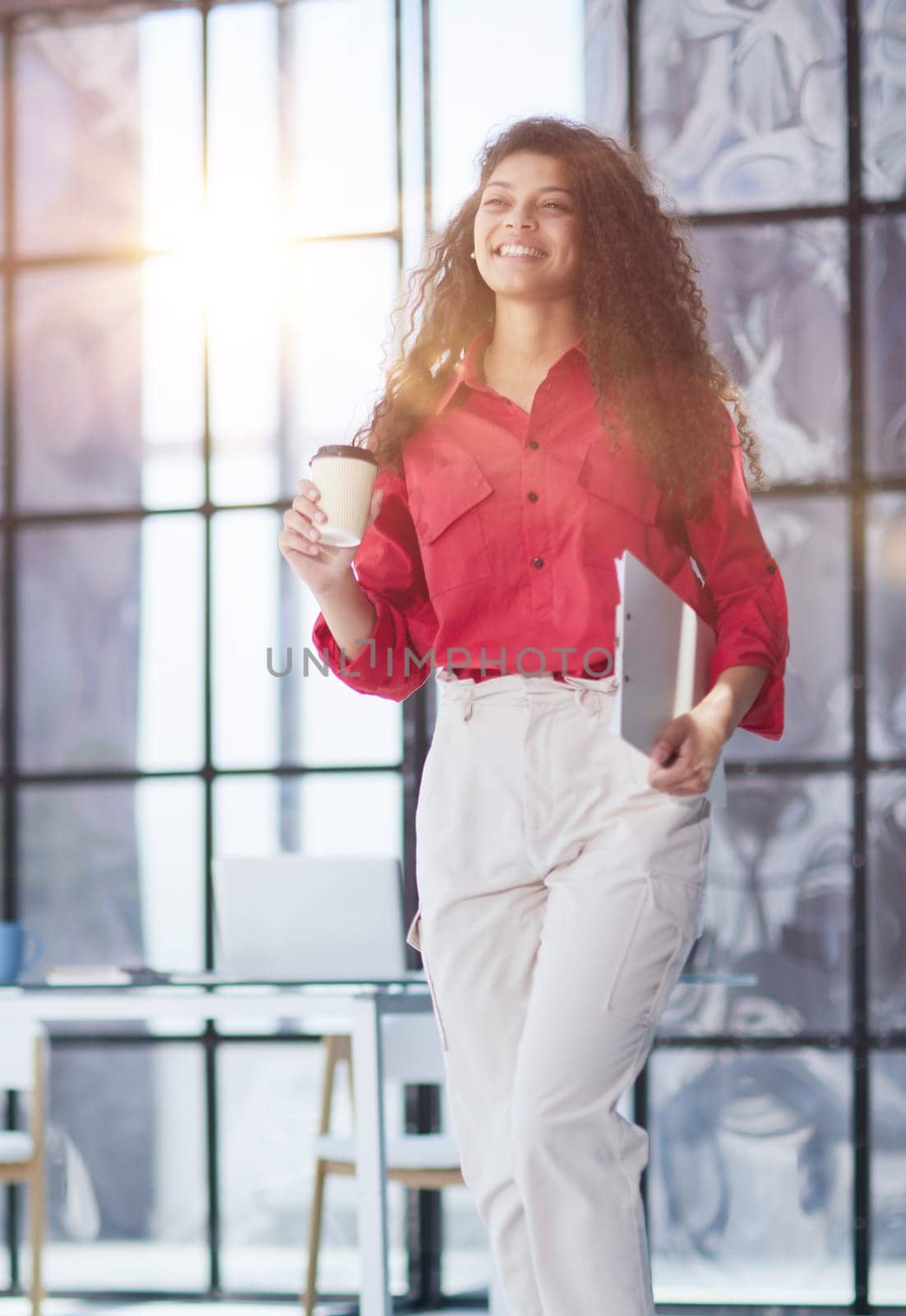 Im ready to start the day. an attractive young businesswoman standing alone in the office with her arms folded