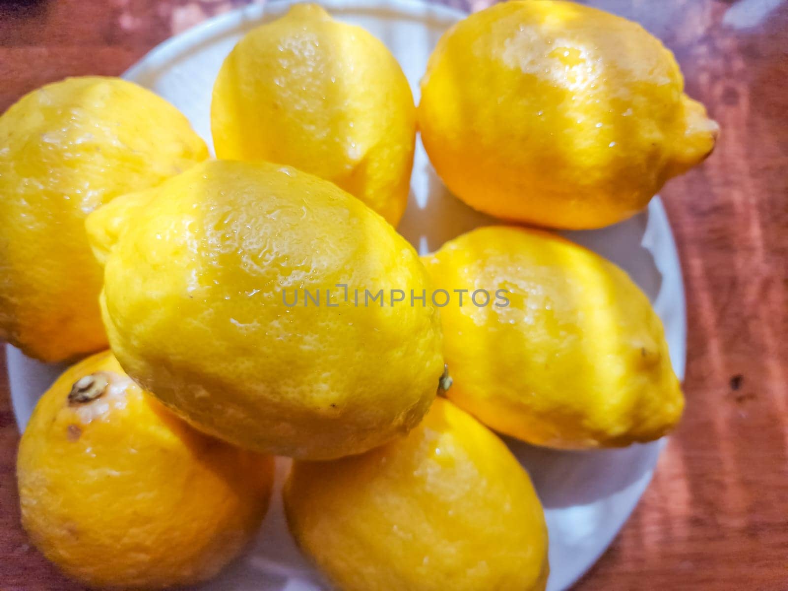Juicy ripe flying yellow lemons, green leaves on light gray background. Creative food concept. Tropical organic fruit citrus vitamin C.