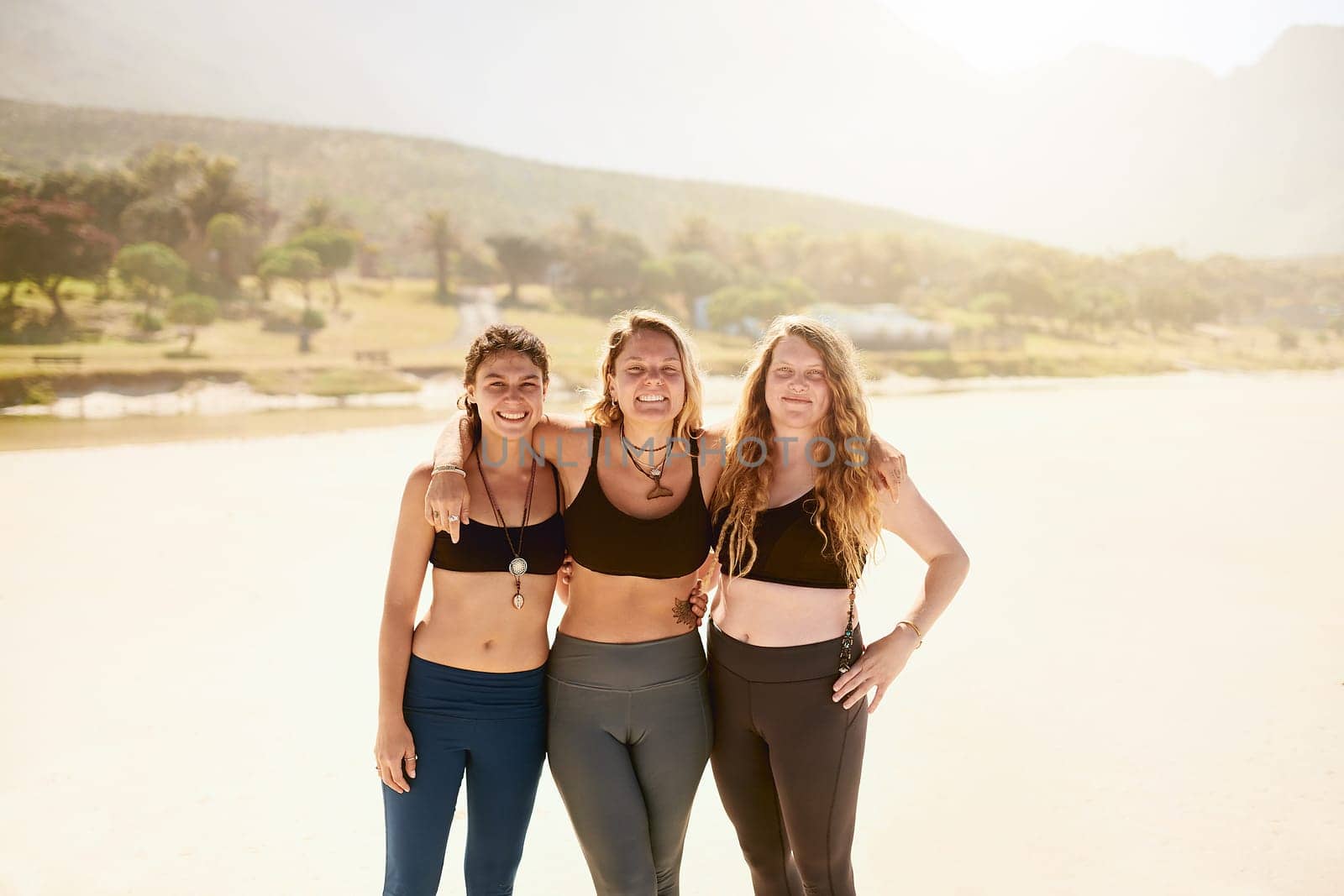 Yoga brought us together. three beautiful young women at the beach for a yoga session