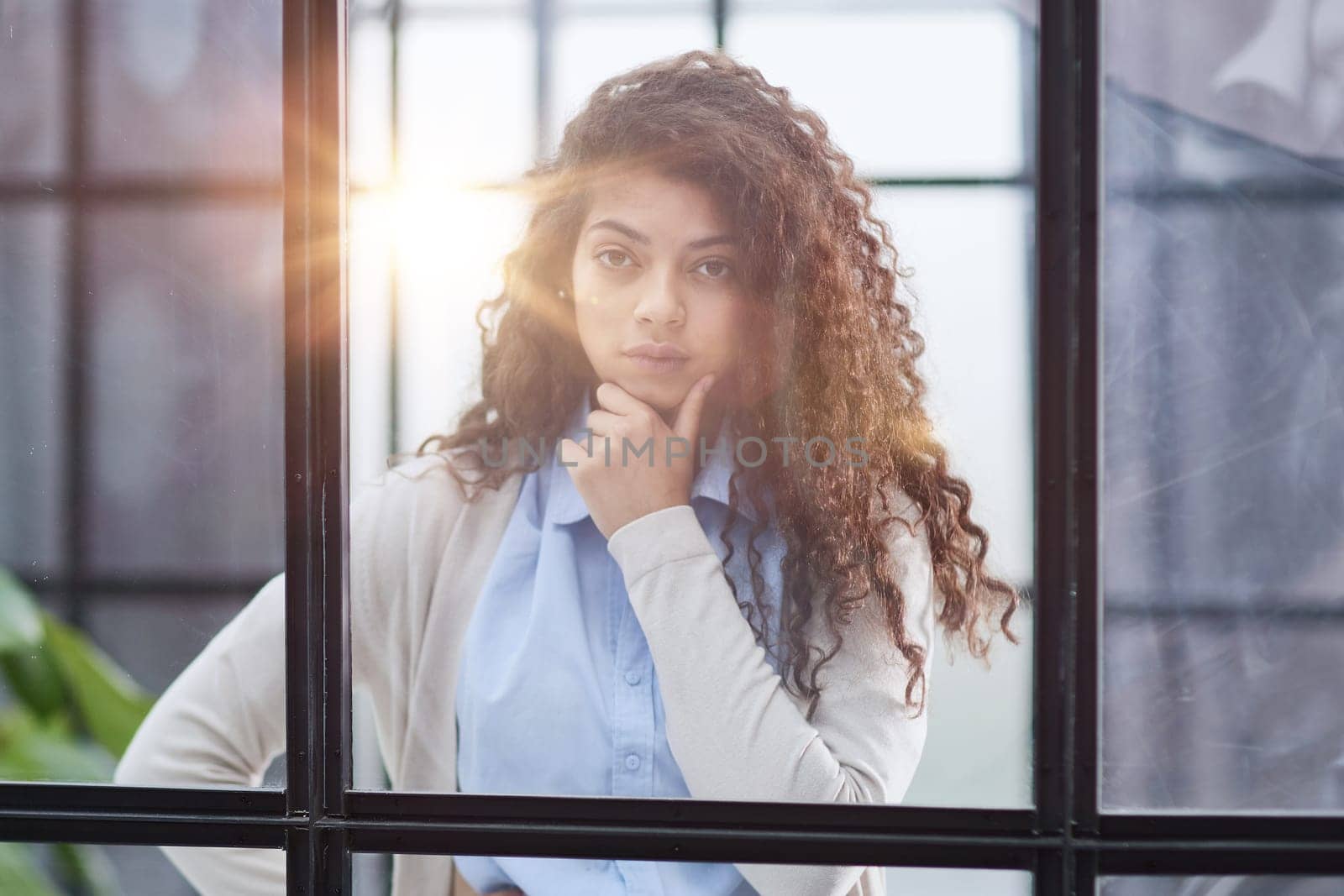 from behind the glass. young business woman thinking about something