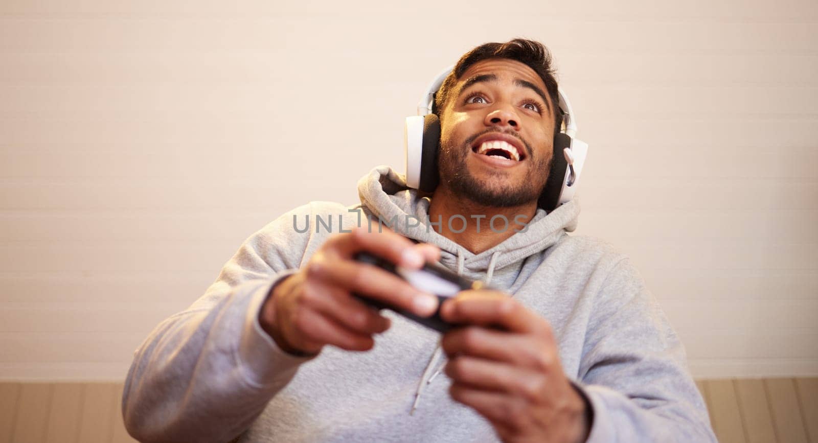 Man play video games, headphones and controller for esports, online streaming and happy at home. Male gamer, smile with entertainment and excited about gaming competition, tech and cyber streamer.
