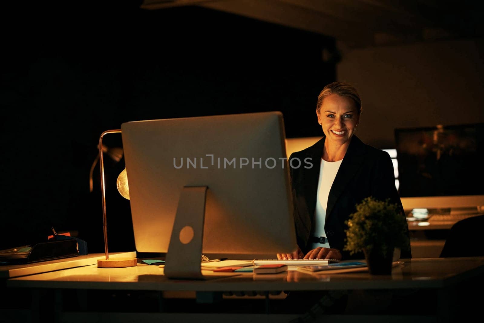 I dont mind putting in extra hours to satisfy clients. a mature businesswoman working late at the office. by YuriArcurs