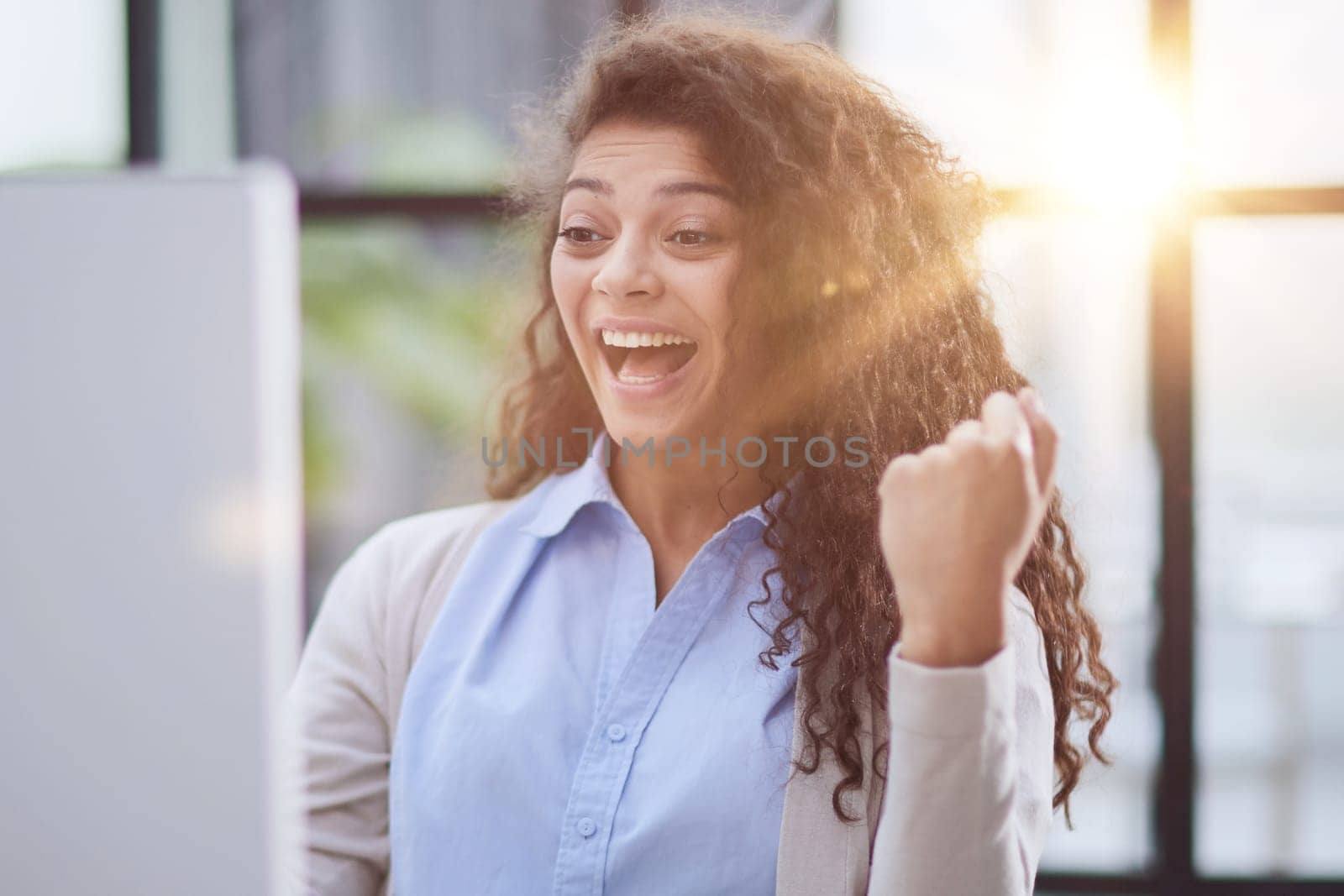 expressive young woman open mouth checking discounts for online shopping sitting at desktop .
