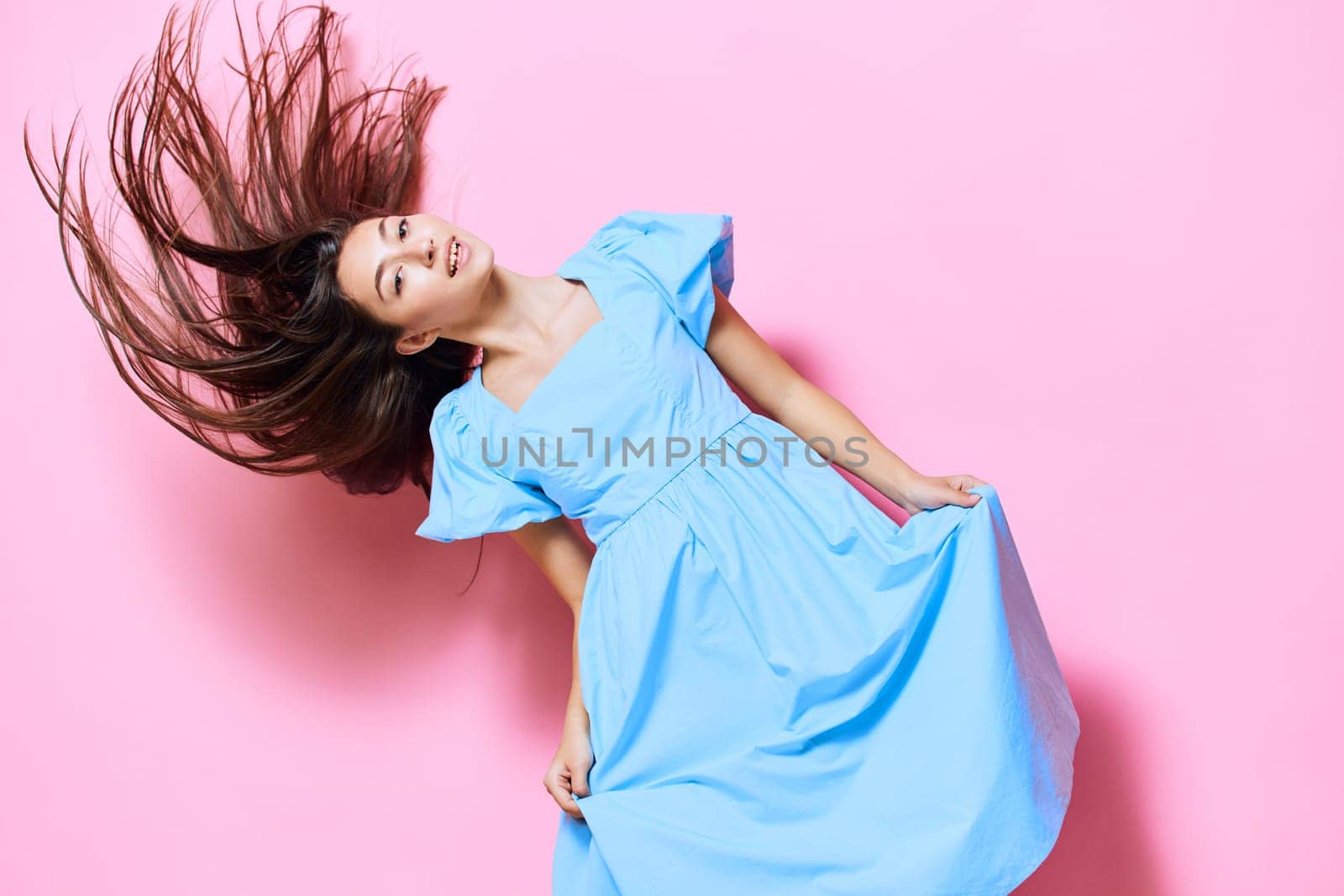 woman style copy fashion expression warm summer pastel young model brunette studio blue relax dress pink beautiful hair person pretty smile space