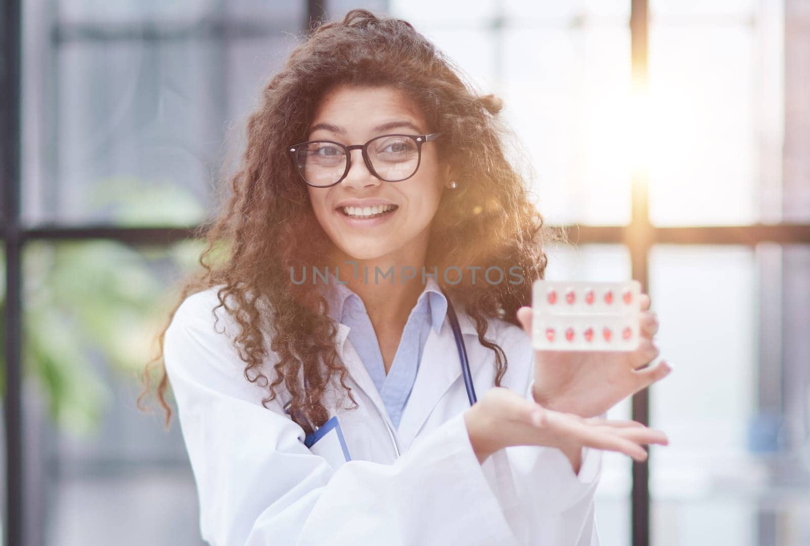 Portrait of young female doctor in white coat at workplace