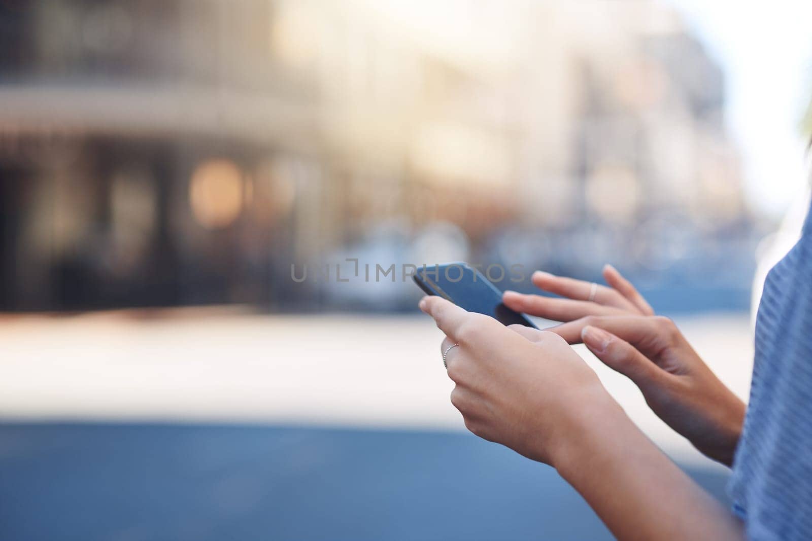 Staying connected on the go. an unrecognizable young woman sending text messages while out in the city