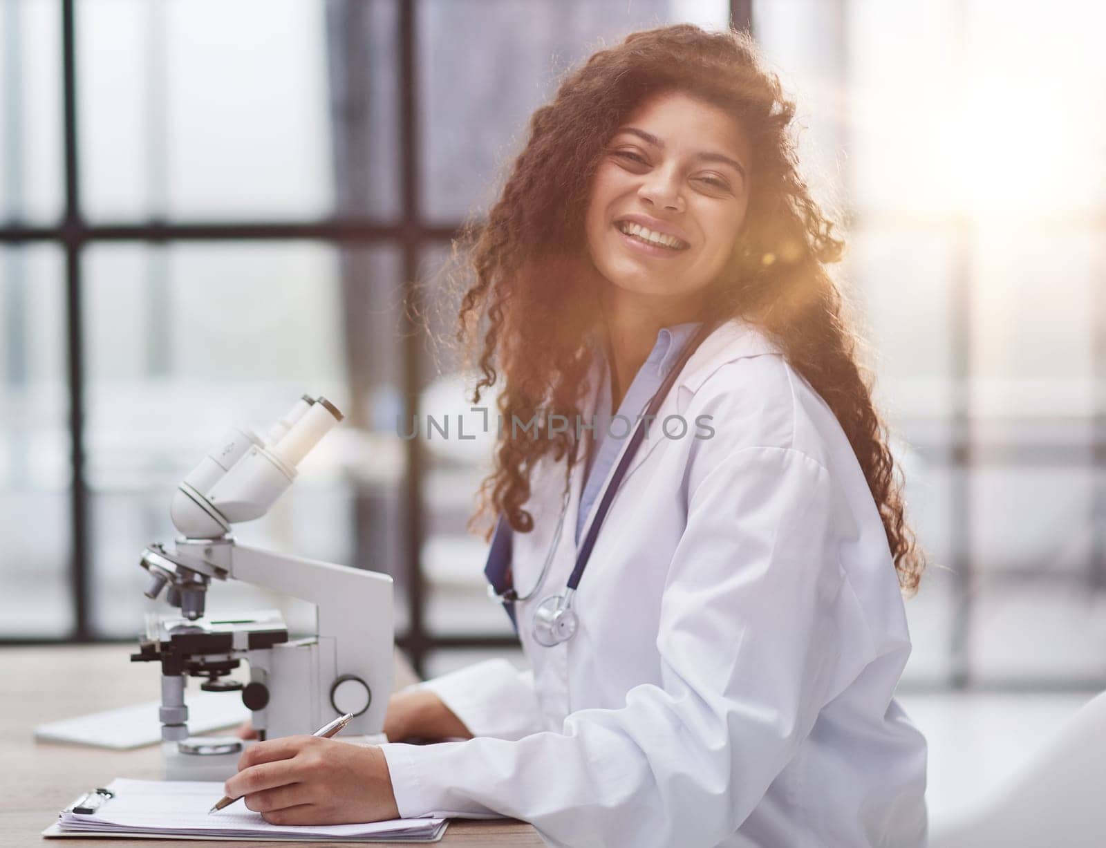 Attractive female scientist looking through a microscope