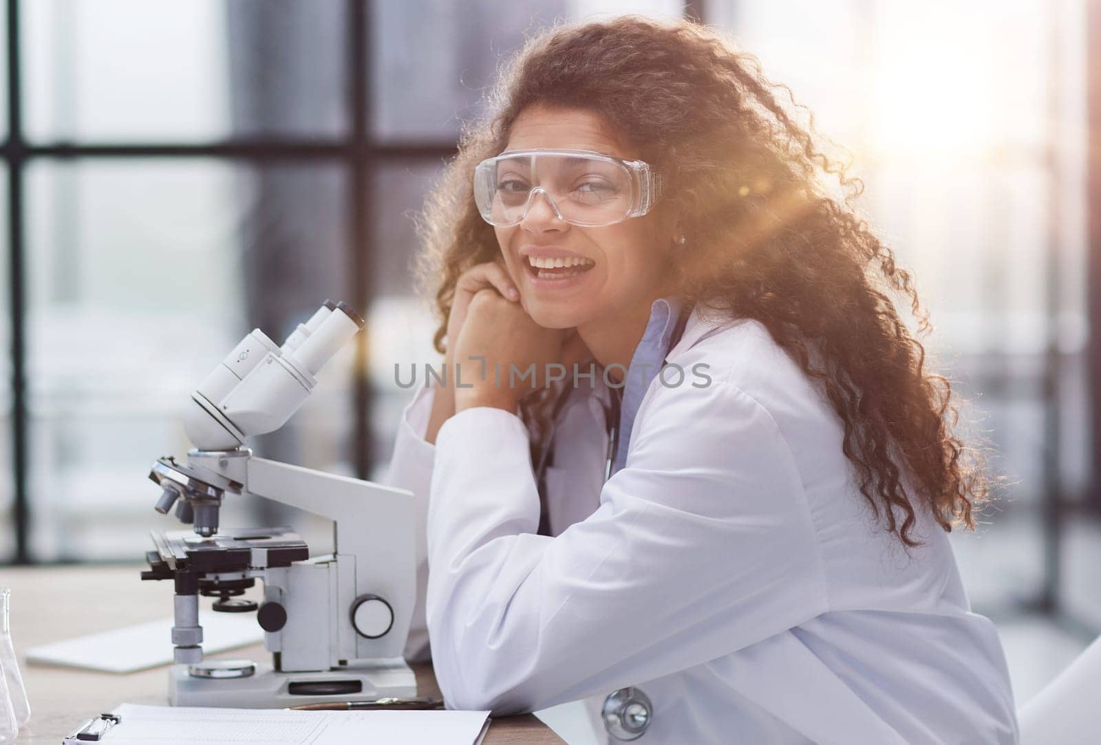 Young woman in biological laboratory. Attractive young female scientis. Scientist using a microscope in a laboratory