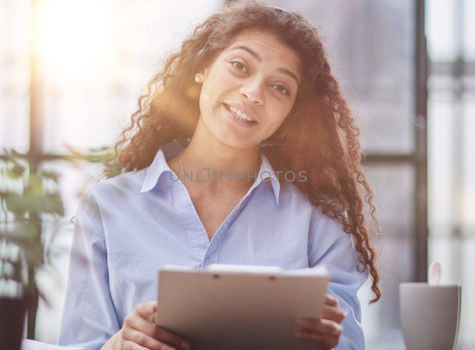 Smiling businesswoman or helpline operator with headset and computer at office