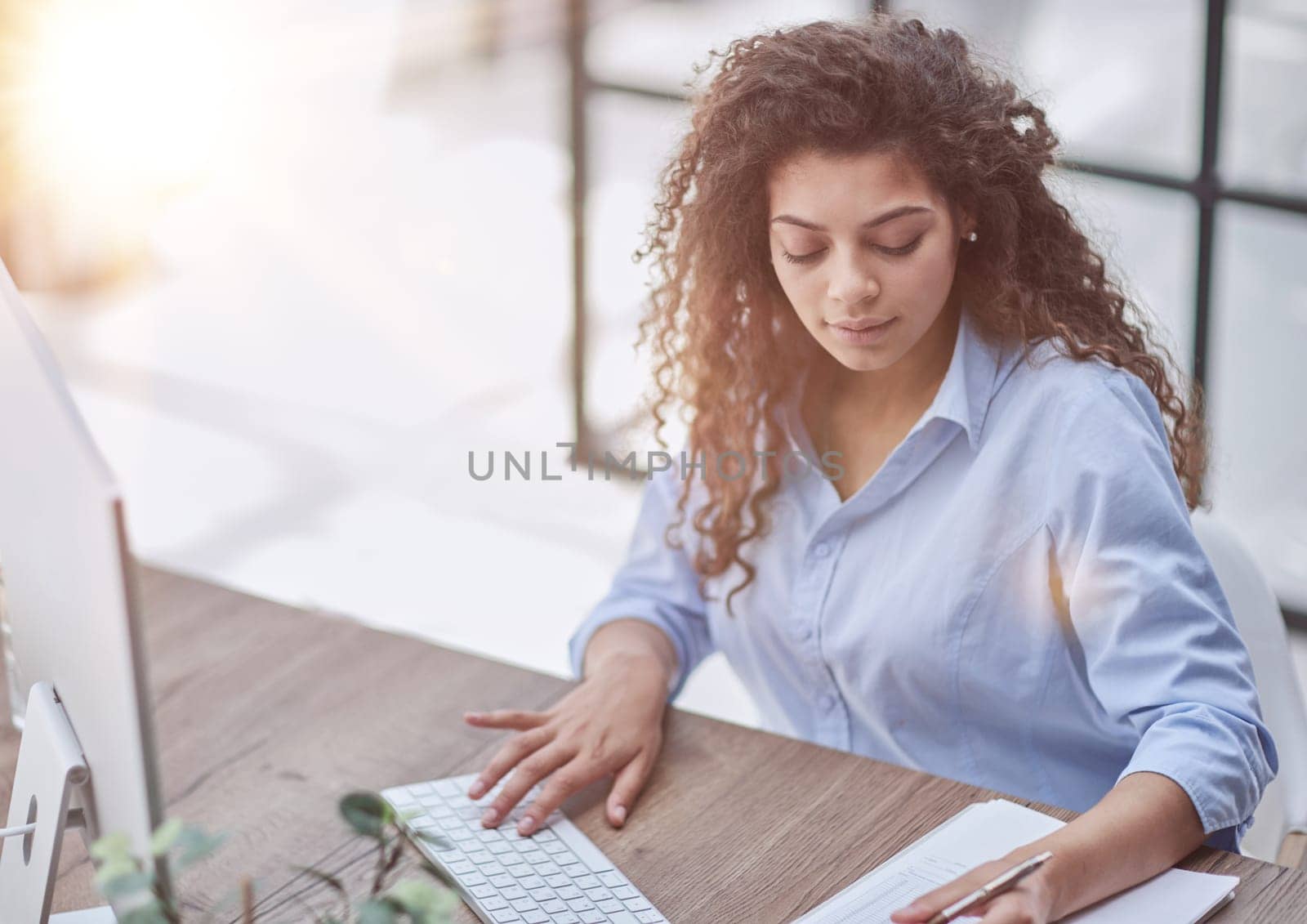 Smiling businesswoman or helpline operator with headset and computer at office