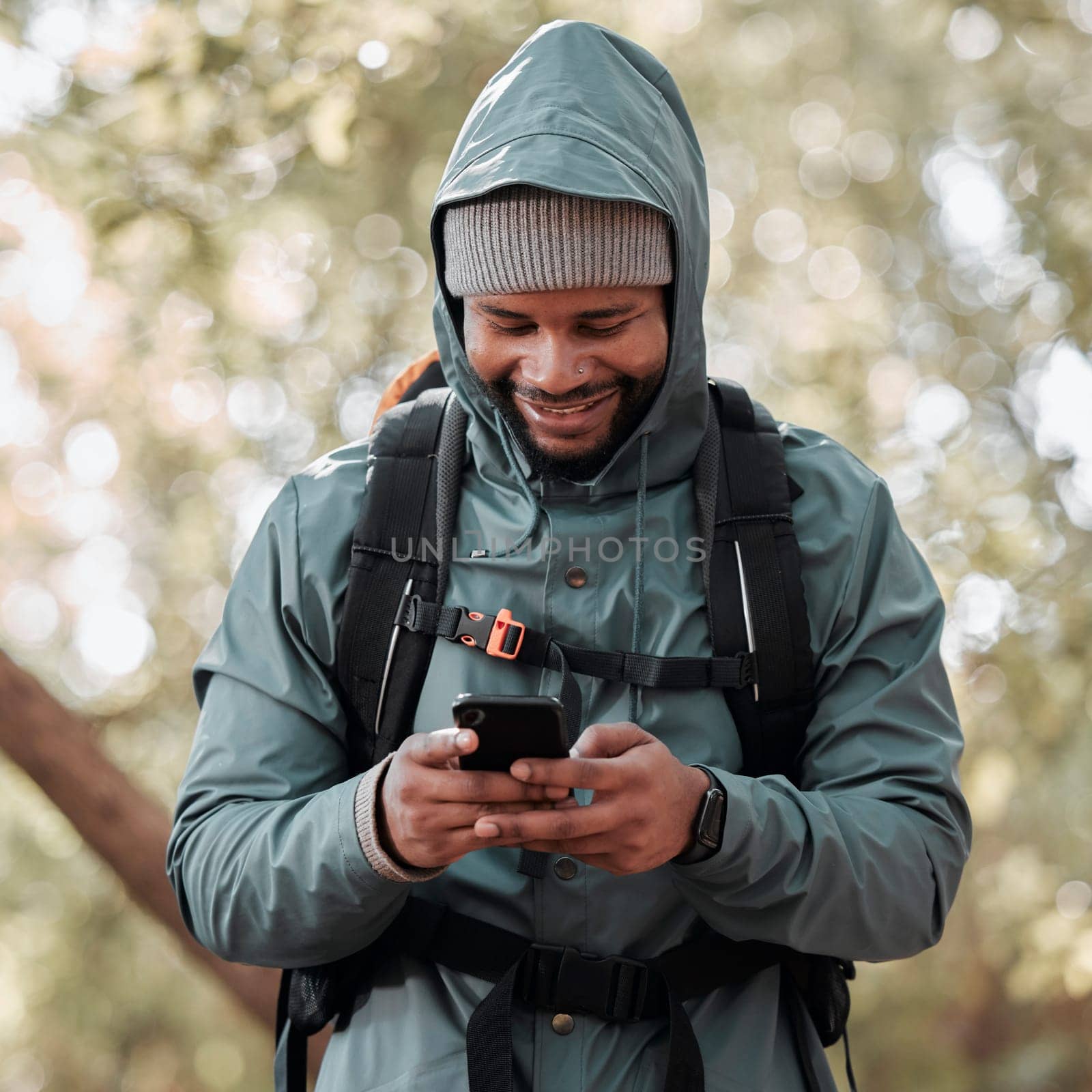 Black man, phone and smile for hiking communication, social media or chat in nature outdoors. Happy African male person or hiker smiling on mobile smartphone for trekking, travel or online location by YuriArcurs