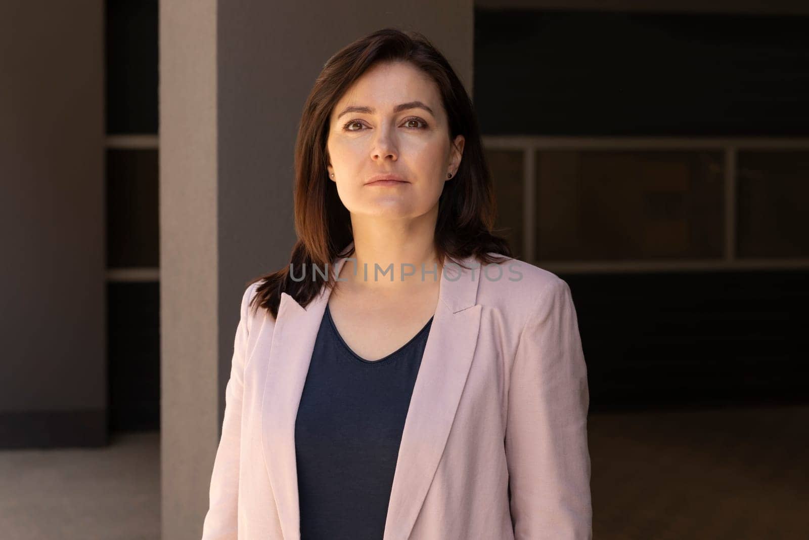 Portrait Confident Mature 40 yo Beautiful Woman, Professional. Intelligent Caucasian Burnette Female With Brown Eyes Looks At Camera, Wears Pink Jackets, Blue Shirt. Horizontal Plane. Business Concept