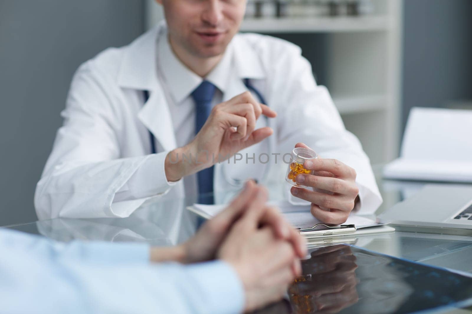 Pharmacist showing up a yellow pills in bottle