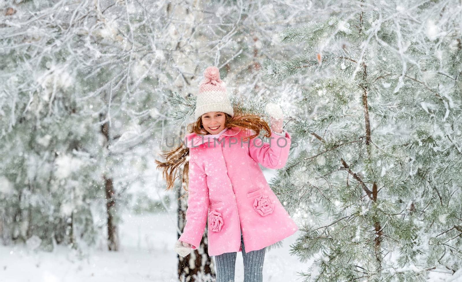 Sweet child having fun outside in the winter, playing with her long hair