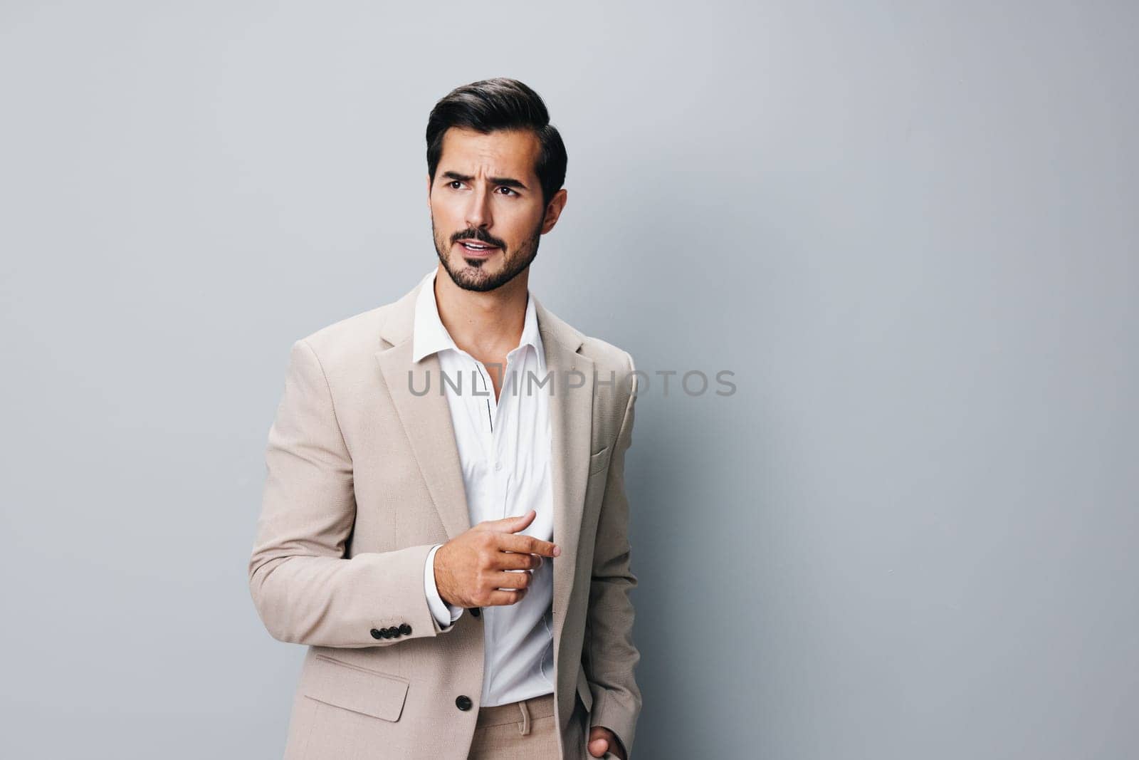 confident man male standing tie young portrait arm happy handsome business suit beige eyeglass smiling businessman office grey corporate isolated copyspace