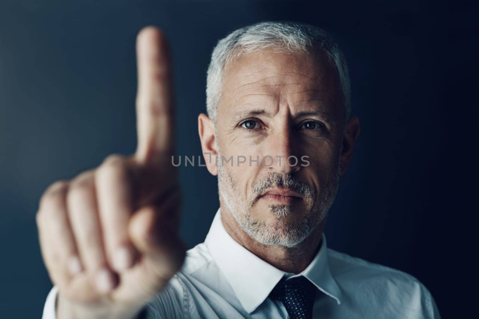 Swiping his way to success. Portrait of a focussed businessman holding up his finger as if using a touchscreen in the office
